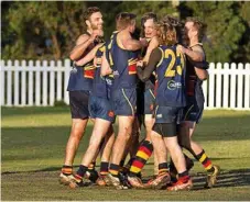  ??  ?? A group of USQ Cougars players come together as the final siren goes in their grand final.