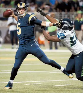  ??  ?? Nick Foles, quarterbac­k de los Rams, realiza un pase ante la presión defensiva de Cliff Avril, defensive end de los Seahawks.