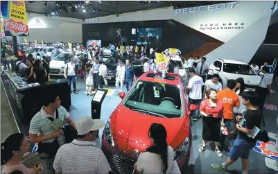  ?? KUN SHAO / FOR CHINA DAILY ?? Cars produced by Dongfeng Peugeot Citroen Automobile Co catch visitors’ eyes at an auto expo in Wuhan, Hubei province.