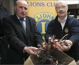  ??  ?? Ray Lawlor and Myles Courtney from New Ross Lions Club with boxes of spectacles.