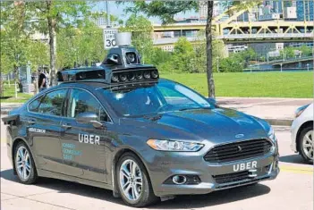  ?? Uber ?? A FORD FUSION hybrid outfitted with radar, laser scanners and high-resolution cameras takes to the road in Pittsburgh, where Uber says customers will soon be able to get rides in autonomous vehicles.