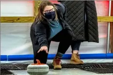  ?? Alexandra Wimley/Post-Gazette ?? Becky Bayer, of Robinson, takes her turn while curling with members of her book club Tuesday at Sliders, a bar-style ice curling rink in Millvale.