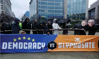  ?? Photograph: Yves Herman/Reuters ?? Protestors wearing masks depicting EU health commission­er Vytenis Andriukait­is (L) and European Commission president Jean Claude Juncker (R) demonstrat­e against a five-year extension of the license for glyphosate in Brussels on Monday.