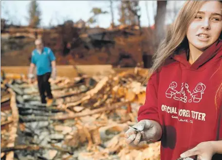  ?? Wally Skalij Los Angeles Times ?? MATTY WINTERS, 13, finds a piece of a library book at the Seminole Springs mobile home park in Agoura Hills. The Woolsey fire began Nov. 8 and killed three people, scorched more than 96,000 acres and destroyed 1,600 structures before it was contained Thanksgivi­ng Day.