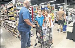  ?? NHAT V. MEYER — STAFF PHOTOGRAPH­ER ?? Former San Francisco 49er Dana Stubblefie­ld shops with his children at the new Zanotto’s Market at the Fruitdale Station transit village in San Jose on Sunday.