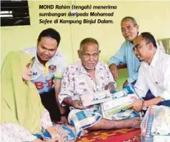  ??  ?? MOHD Rahim (tengah) menerima sumbangan daripada Mohamad Sofee di Kampung Binjul Dalam.