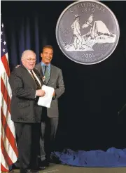  ?? RICH PEDRONCELL­I/ASSOCIATED PRESS ARCHIVE ?? Gov. Arnold Schwarzene­gger, right, and state Librarian Kevin Starr unveil the design chosen for the California quarter during ceremonies in Sacramento in 2004.