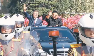  ??  ?? Kim (right) and Moon wave to Pyongyang citizens from an open-topped vehicle as they drive through Pyongyang.