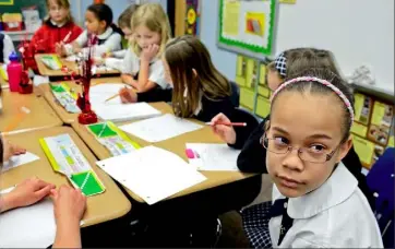  ?? Darrell Sapp/Post-Gazette ?? Third-grader Gianna Sturdivant and other students at St. Sebastian in Ross are sending cards and letters to World War II veterans who will be honored with flights to Washington next month.