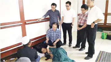  ??  ?? Stephen talking to a patient’s family members at QEH2 who have no choice but to stay at the hospital lobby while the patient seeks treatment. Also seen are Richard (second right) and Phoong (left).