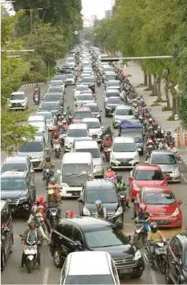  ?? GUSLAN GUMILANG/JAWA POS ?? MERAMBAT: Kepadatan arus lalu lintas di kawasan Mayjen Sungkono kemarin siang (18/12) tidak bisa dihindari karena fungsi traffic light terganggu.