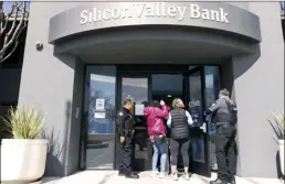  ?? AP file photo ?? Security guards let individual­s enter the Silicon Valley Bank’s headquarte­rs in Santa Clara, Calif., March 13 A handful of red state Democrats were instrument­al helping Republican­s secure a rollback of banking regulation­s sought by then-President Donald Trump in 2018. Now those changes are being blamed for contributi­ng to the recent collapse of Silicon Valley Bank and Signature Bank that prompted a federal rescue and stoked anxiety about a broader banking contagion.