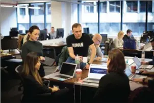  ?? KEVIN HAGEN/THE NEW YORK TIMES ?? Michael Tiffany (centre) chief executive of the computer security firm White Ops, works with team members at the cyber-security company’s office in New York on December 20.