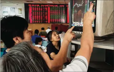  ??  ?? Stock investors check a computer screen showing stock prices at a brokerage house in Beijing on July 20, 2015.