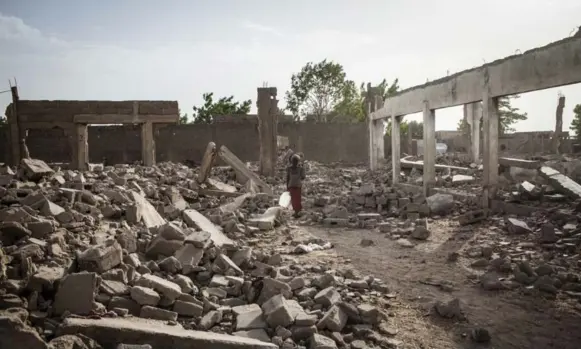  ?? JANE HAHN/FOR THE WASHINGTON POST ?? A girl walks through destroyed homes in Banki, Nigeria. At least 5,000 Nigerian refugees in Cameroon were expelled to a region under frequent attack by insurgents, according to UN officials.