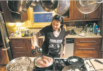  ??  ?? Cezin Nottaway, an Algonquin who runs a catering business, pours tea into the sauce for her smoked moose, at home in Maniwaki, Quebec, Canada.