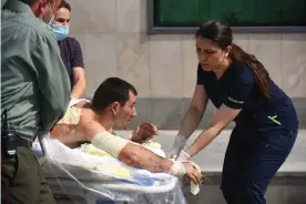  ?? Photograph: Armenian foreign ministry/AFP/Getty Images ?? Armenian medics help a man said to have been injured in clashes in Azerbaijan’s breakaway region of Nagorno-Karabakh.