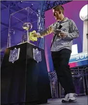  ?? MARK HUMPHREY / ASSOCIATED PRESS ?? Justin Tacheny polishes the case around the Vince Lombardi Trophy at the NFL Experience attraction Friday in Minneapoli­s.