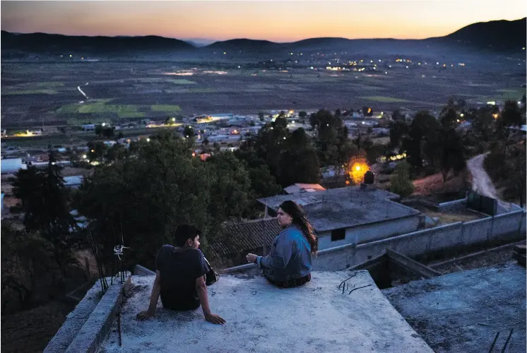  ?? PHOTOS: SARAH L. VOISIN / WASHINGTON POST ?? Bryan Quintana-Salazar, 14, and his sister, Lourdes (Lulu) Quintana-Salazar, 16, sit on the roof of their grandmothe­r’s home in Mexico.