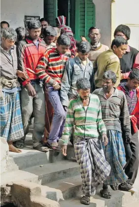  ??  ?? Thirteen men arrested in the gang rape of a woman stand on the steps of a court in Bolpur, India, on Jan. 23. Police allege the attackers included the headman of her village.