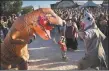  ?? FILE PHOTO ?? PJ Granules, 4, of Albuquerqu­e, rushes to break up a fight between festivalgo­ers dressed as a dinosaur and a shark during the Music on the Mothership Festival at Taos Mesa Brewing.