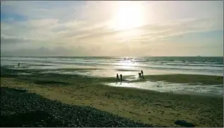  ??  ?? Social distancing being maintained by a family walking a Kerry beach.