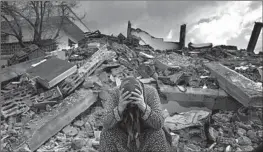  ?? Khalil Hamra Associated Press ?? A WOMAN sits in the rubble of a destroyed building Tuesdy in Nurdagi, a town on the outskirts of Osmaniye in southern Turkey, a day after a 7.8 earthquake.