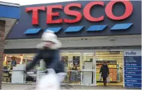  ??  ?? LONDON: This file photo shows customers leaving a branch of a Tesco supermarke­t in London.—AFP