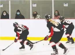  ?? TIM KROCHAK / BLOOMBERG ?? Parents wear protective masks while watching their children play hockey in Dartmouth, N.S., on Saturday. The province now has 45 confirmed cases of COVID-19.