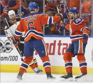  ?? JASON FRANSON, THE CANADIAN PRESS ?? Oilers’ Adam Larsson and Leon Draisaitl celebrate a goal Sunday night. Edmonton won, 7-1, forcing Game 7 on Wednesday in Anaheim, where the Ducks have lost a Game 7 each of the past four years.