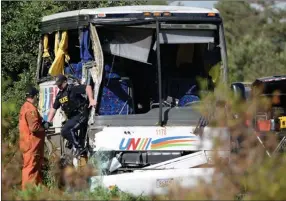  ?? The Canadian Press ?? OPP officers work at the site of a crash involving a tour bus on Highway 401 West, near Prescott, Ont., on Monday.