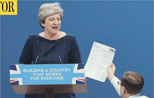  ?? PAUL ELLIS / AGENCE FRANCE-PRESSE / GETTY IMAGES ?? Protester/comedian Simon Brodkin gives a mock dismissal form to British Prime Minister Theresa May in Manchester on Wednesday.