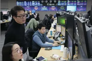  ?? (AP/Ahn Young-joon) ?? Currency traders watch monitors at the foreign exchange dealing room of the KEB Hana Bank headquarte­rs in Seoul, South Korea, on Tuesday.