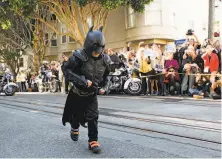  ?? Michael Macor / The Chronicle 2013 ?? Miles Scott, as Batkid, runs to protect a damsel in distress along the Hyde Street cable car line on Nov. 15, 2013.