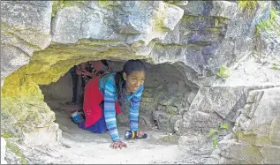  ?? CHELSEY LEWIS / CLEWIS@JOURNALSEN­TINEL.COM ?? Synphanie Williams crawls through a cave at Cherney Maribel Caves County Park in Cooperstow­n. Williams was on a tour of the park with her Girl Scout troop from Manitowoc.