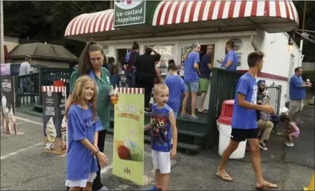  ?? Ben haStY - MeDianeWS groUP ?? hannah long, 9, her brother thomas long, 7, and her mother tiffany long, all of exeter, survey raffle items during a fundraiser for Melissa Dawson at the rita’s in Mount Penn thursday. Dawson, 48, is the lone survivor of a car crash that killed her husband and two children in north caroline earlier this month.