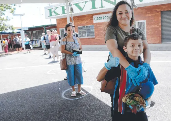  ?? Picture: STEWART McLEAN ?? WELL SPREAD: Joanna Hill and her son Mateo, from Bayview Heights, stay separated from others waiting to vote early at Cairns Showground.