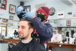  ?? YOGESH GOVAN ?? NADEEM Andrews gives Sam Spiller a trim at Yogi’s Barber Shop in Cape Town.
|