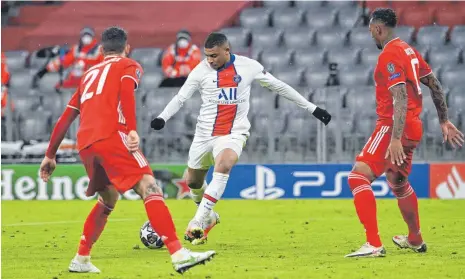  ?? FOTO: SVEN HOPPE/DPA ?? Der Mann des Spiels: Kylian Mbappé (Mitte) nimmt Maß für das 2:3, sein zweites Tor beim Gastspiel von Paris St. Germain in München. Lucas Hernández (links) und Jérôme Boateng haben das Nachsehen.