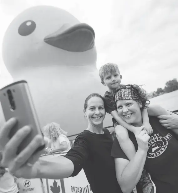  ?? DAX MELMER ?? Kristina Gibson, left, and Tracey Hawksworth with their son, Nate Gibson-Hawksworth, 4, in front of Mama Duck at the Canuck It Up! festival in Amherstbur­g on Aug. 6.