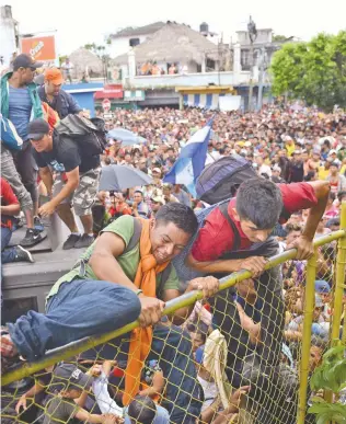  ??  ?? Miles de migrantes hondureños desafiaron la valla fronteriza que separaba Tecún Umán, en Guatemala, de México, en su intento, el viernes, por llegar a Ciudad Hidalgo, en Chiapas.