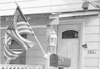  ?? Tony Dejak / Associated Press ?? A tattered flag flies Thursday in front of a Cleveland home where Julian Hernandez lived with his father, Bobby. Thirteen years after Julian was allegedly snatched from his Alabama home at age 5 by his father, he has been found living under an assumed...