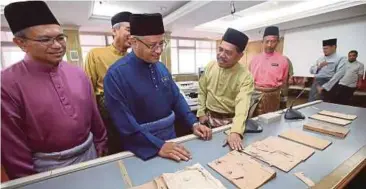  ??  ?? SYED Ahmad Fuad (dua kiri) melihat dokumen perkahwina­n lama selepas Majlis Pelaksanaa­n Pengimejan Digital Dokumen Lama Nikah Cerai dan Rujuk Orang Islam Negeri Pahang di Kuantan, semalam