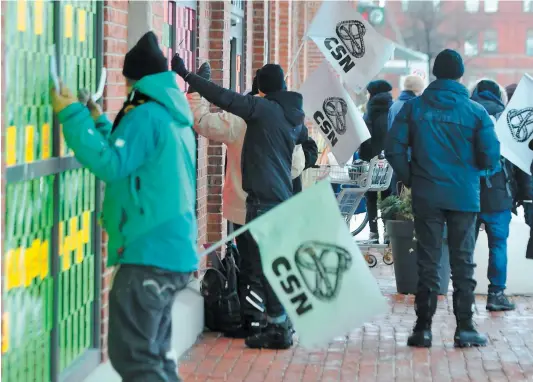  ?? PHOTO AGENCE QMI, MARC ALAIN TRUDEAU ?? Des grévistes ont tapé avec des fourchette­s et des couteaux dans les vitrines de la succursale de la SAQ de la rue AndréLaure­ndeau, à Montréal, hier. Les employés syndiqués en étaient à leur deuxième de trois journées consécutiv­es de grève.