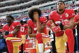  ?? THEARON W. HENDERSON / GETTY IMAGES ?? A movement started by former San Francisco 49ers player Colin Kaepernick (center), shown kneeling before a game on Oct. 2, 2016, has resulted in a new policy announced by the NFL.