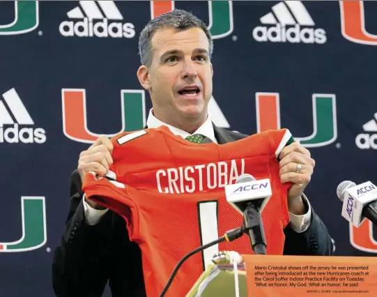  ?? MATIAS J. OCNER mocner@miamiheral­d.com ?? Mario Cristobal shows off the jersey he was presented after being introduced as the new Hurricanes coach at the Carol Soffer Indoor Practice Facility on Tuesday. ‘What an honor. My God. What an honor,’ he said.