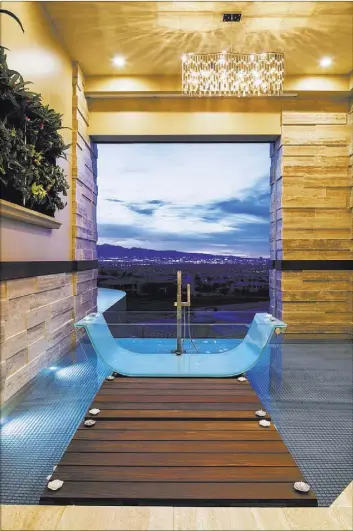  ?? COURTESY OF SUN WEST CUSTOM HOMES ?? Sun West Custom Homes’ showcase home features a master bath that can be open to the pool area and the Las Vegas skyline.
