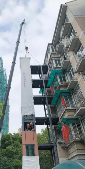  ??  ?? Workers are busy installing the new elevators for Binfen Residentia­l Community in Hangzhou. — Ti Gong