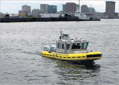  ?? STEVEN SENNE/AP ?? An experiment­al workboat capable of autonomous navigation makes its way last month around Boston Harbor.