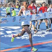  ??  ?? Solomon Deksisa approcahes to cross the fininish line to win the men’s category of the Mumbai Marathon.